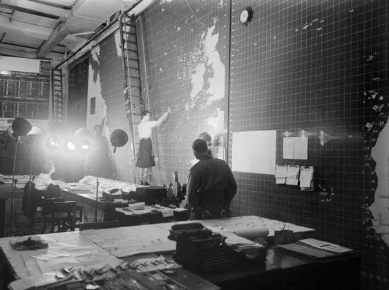 The Operations Room at Derby House in Liverpool, the headquarters of the Commander-in-Chief Western Approaches, September 1944. In the operations room at Derby House, Liverpool, where up to the minute shipping positions are shown on a huge indicator, a Wren can be seen up a ladder making an alteration to an indicator on one of the large, wall mounted maps. This is one of the scenes for an Anglo-American official film covering the battle of the Atlantic right up to D-Day, being shot by Army Film Unit cameramen at the headquarters of the Commander in Chief Western Approaches. Copyright: xpiemagsx admiralww2pie10322-1609 !ACHTUNG AUFNAHMEDATUM GESCHÄTZT!