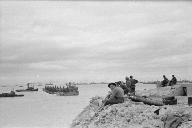 The Royal Navy during the Second World War- the Campaign in Normandy, June 1944 Mulberry Harbour, Arromanches: The arrival of the parts of the Mulberry Ports along with the sinking of the block ships to form a protective breakwater for the port and the sinking of the Phoenixes and Whales that make up the Mulberry. Here a section of a Whale is being towed into position. In the foreground men are sat on the shore watching the construction of the harbour. Copyright: xpiemagsx admiralww2pie10322-3985 !ACHTUNG AUFNAHMEDATUM GESCHÄTZT!