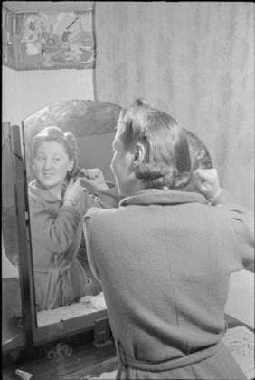 A Girl Joins Up- Women s Factory War Work, England, UK, May 1941 Vera Elliott is up early to get ready for her first day at the factory. Here, she is brushing her hair in front of the mirror in the bedroom she has been given in the home of her new landlady Mrs Wright. Copyright: xpiemagsx moiswwpiemags29032022-54 !ACHTUNG AUFNAHMEDATUM GESCHÄTZT!