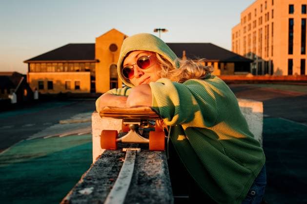 woman leaning on her skateboard in a car park at sunset Southampton, England, United Kingdom CR_RABE220822-1025767-01 ,model released, Symbolfoto