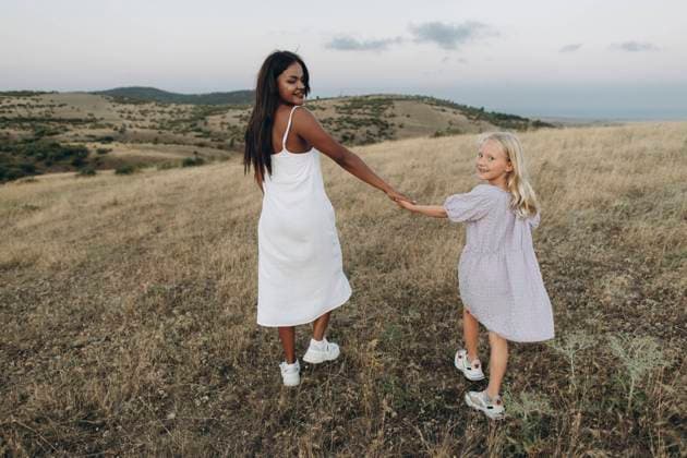 Smiling woman and girl holding hands walking in meadow model released, Symbolfoto, SIF00364