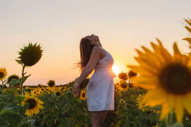 Carefree woman enjoying weekend at sunflower field on sunset model released, Symbolfoto, OSF00729