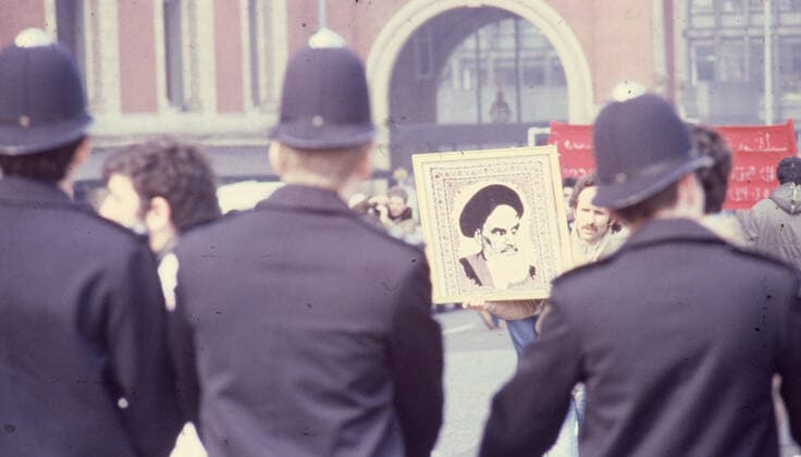April 30, 1980, London, United Kingdom: Police on crowd control of the Iranian supporters carrying a picture of the Ayatollah Khomeini in a protest march in London during the six-day siege of the Iranian Embassy. From 30 April to 5 May 1980, a group of six armed Iranian dissidents, opposed to Ayatollah Khomeini, the religious leader who came to power in 1979, took over the Iranian embassy on Prince s Gate in South Kensington, London. The Iranian group took 21 hostages two of whom were killed. Near to the scene of the siege, supporters of Khomeini made their views known with a protest. The dramatic six-day siege ended when elite British SAS troops stormed the building to rescue the remaining 19 hostages. Five of the gunmen were killed. Londo - ZUMAk09_ 19710627_jtc_k09_906 Copyright: xKeystonexPressxAgencyx