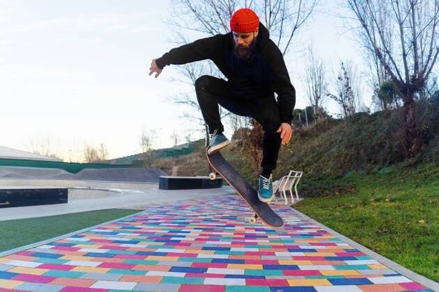 IMAGO Creative: Fit durch den Herbst Bearded male skater jumping with skateboard above colorful paved walkway while performing stunt in skate park in autumn IsraelDeLago_ID600_22513_006 Copyright: xIsraelxDexLagox Model Released