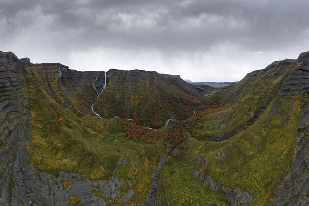 Creative Highlights World Amazing landscape of massive rocky mountain with waterfall and autumn vegetation against dramatic gray cloudy sky JuanLopez_ID551_21579_029 Copyright: xJuanxLopezx Model Released