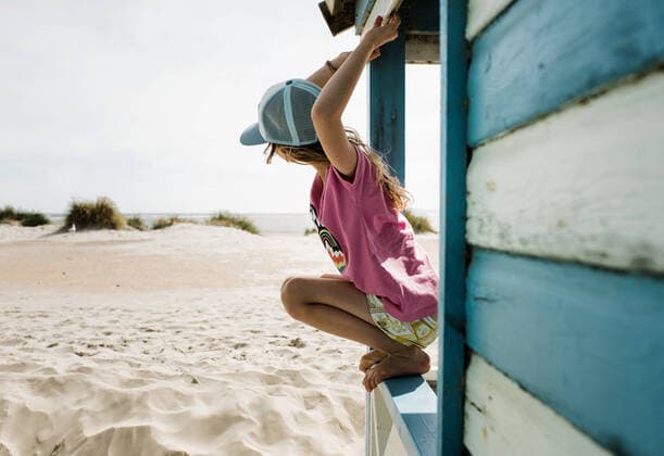 Creative Highlights Symbolbilder girl hanging from a beach hut checking the surf on a sunny day West Wittering, England, United Kingdom CR_RABE220721C-1006219-01 ,model released, Symbolfoto