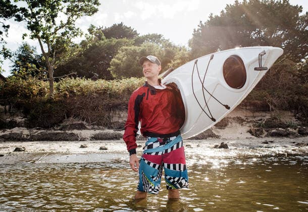 Creative Highlights Symbolbilder man happily stood in the sea holding a kayak ready to adventure Studland, England, United Kingdom CR_RABE220721C-1006258-01 ,model released, Symbolfoto