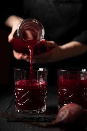 Freshly squeezed beet juice being poured into a decorative glass Freshly squeezed beet juice being poured into a decorative glass Copyright: xAlanaxHaldanx AHA180821-8
