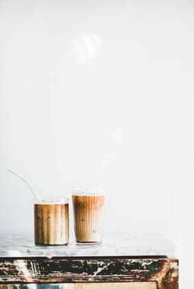 Iced latte coffee in glasses, whate wall at background Homemade iced latte coffee in glasses with straws on grey marble table, white wall at background, copy space, vertical composition. Summer cold refreshing drink concept Copyright: xAnnaxIvanovax AI290719-5