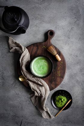 Matcha tea with a kettle and whisk on a dark surface Matcha tea with a kettle and whisk on a dark surface Copyright: xHeidixRichterx HR030621-21
