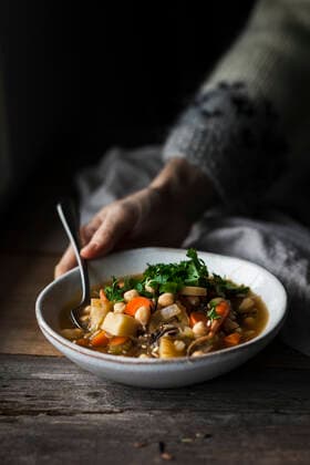 A cook serving a bowl of vegetable soup with chickpeas. A cook serving a bowl of vegetable soup with chickpeas. Copyright: xHeidixRichterx HR231121-12