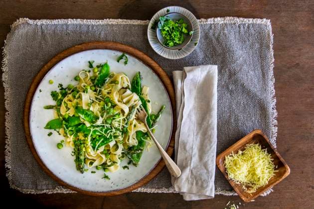 Freshly made Pasta Primavera with green asparagus, peas and sugar snaps on stoneware plate over wooden background with copy space Copyright: xClaudiaxHirschberger,xArnexSchmidtx KAS130519-30