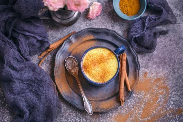 Golden milk turmeric latte served in a blue cup Golden milk turmeric latte served in a blue cup Copyright: xLilixBasicxCapaccettix LBC250118-3