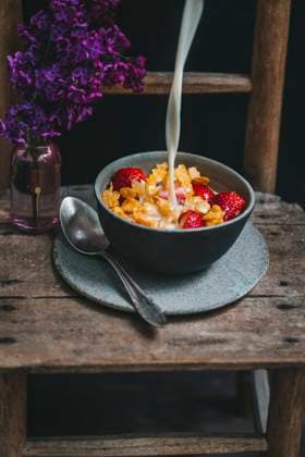 Bowl of corn flakes and fresh strawberries with milk being poured on top Bowl of corn flakes and fresh strawberries with milk being poured on top Copyright: xLilixBasicx LBC290422-7