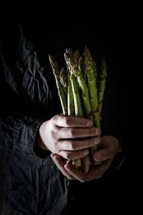 Bundle of green asparagus Bundle of raw organic green asparagus in dirty man s hand in black shirt. Copyright: xNatashaxBreenx NB080519-8