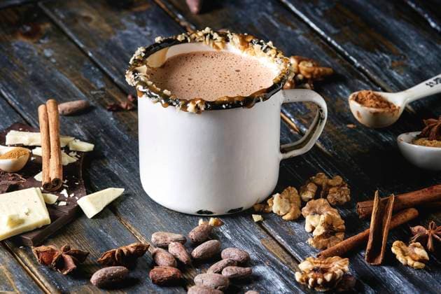 IMAGO Creative: Winter Rezepte Mug of hot chocolate Vintage mug of hot chocolate, decor with nuts, caramel, spices. Ingredients above. Chopped dark and white chocolate, cocoa beans, anise over old wooden table. Dark rustic style Copyright: xNatashaxBreenx NB161017-54