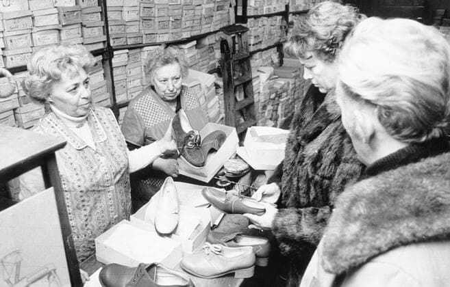 Sachsen, DDR, historisch, Verkauf, Einkaufen, Geschäfte, Läden, Handel, Einzelhandel, Bekleidung, Schuhe: Radebeul, Schuhhaus Tröger, Ingeborg Köhler (links) und Marie Tröger bei einer fachkundigen Beratung, 15.12.1982. Veröffentlichung in Sächsische Zeitung am 21.12.1982: Für Leute auf großem Fuß. Ein kurzer Besuch im Radebeuler Schuhhaus Tröger, von wo aus fast täglich übergroße Schuhe ihre Reise in die Republik antreten. Wie viele Bürger können von sich behaupten, auf großem Fuß zu leben? Näheres darüber erfuhren wir von Frau Tröger, Inhaber des Radebeuler Schuhauses Tröger. In meinem Geschäft kaufen einige hundert Leute Schuhe in Übergrößen , berichtete die freundliche Frau, die im Schuhgeschäft groß geworden ist. Marie Tröger un Copyright: xSZ WaltrautxKossackx