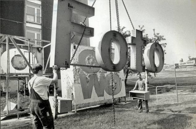 Dresden, historisch, Wende (Umbruch), Rathenauplatz: Werbung für ORWO wird demontiert, 26.05.1993. Veröffentlichung in am 28.07.1990: Langsam sinkt die Orwo-Reklame zu Boden. Auf den Häusern am Rathenau-Platz werden künftig keine Produkte der DDR-Wirtschaft mehr angepriesen. DDR-Reklame verschwindet von Dächern der Innenstadt. Bauaufsichtsamt sprach die Abbruchverfügungen aus. Die Reklame aus vergangenen Zeiten verschwindet von den Dächern im Stadtzentrum. Gestern begann die Demontage auf der Wohnzeile an der Steinstraße. Damit endet der jahrelange Streit um überholte Werbeflächen. Das Bauaufsichtsamt erließ die notwendigen Abbruchverfügungen Die alten Werbeleichen , so Roland Buchholz vom Bauaufsichtsamt auf -Anfrage, werden aus Grü Copyright: xSZ MarionxGröningx