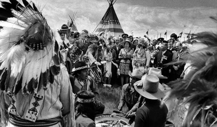 July 5, 1973, CALGARY, AB, Canada: Queen Elizabeth, surrounded by Alberta treaty Indians, watches as a dance of welcome is performed in her honour. The Queen and Prince Philip visited the village July 5, 1973 during a stop in Calgary, AB., to open the Calgary Stampede. (CP PHOTO) CALGARY Canada  - ZUMAc35_ 19730705_zaf_c35_002 Copyright: xThexCanadianxPressx