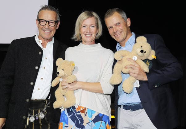 28. Tabaluga Golf Cup Tobias Angerer gewinnt mit seiner Frau Romy Gross-Angerer zusammen die Brutto Wertung beim 28. Tabaluga Golf Cup hier hat der Organisator Michael Roll (links) die Preise - 2 Stoff Teddy Bären überreicht, Tutzing Bayern Deutschland Golfplatz Tutzing