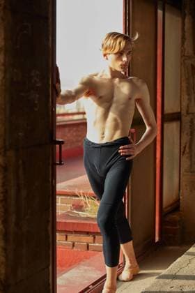 Creative Highlights Symbolbilder Amazing young gymnast in black leotard stretching the arm near window in room and looking away, Model released CienXCienStudio_DancerBoy_48 Copyright: xCienxXxCienxStudiox MR