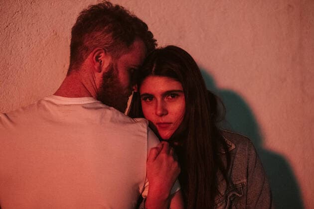 Creative Highlights Symbolbilder Young couple standing close to each other hugging outdoors against a wall under red lights, Model released JakeJakab_CanaryTravels_13 Copyright: xJakexJakabx MR