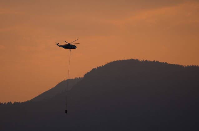 September 12, 2022, HOPE, BC, CANADA: A helicopter with a water bucket battling the Flood Falls Trail wildfire picks up water from the Fraser River, in Hope, B.C., Monday, Sept. 12, 2022. HOPE CANADA  - ZUMAc35_ 20220912_zaf_c35_208 Copyright: xDarrylxDyckx
