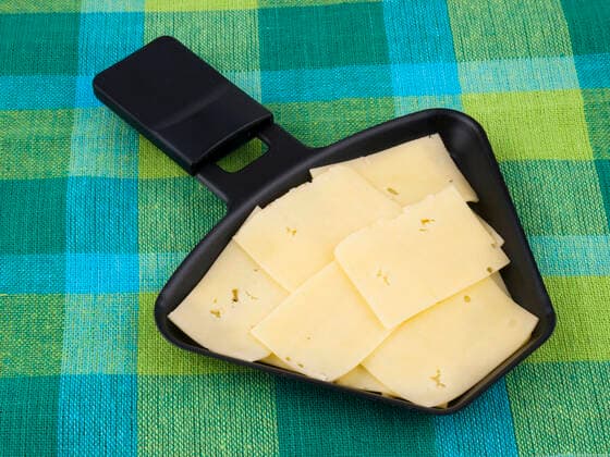 Raclette pan with edam cheese on colorful tablecloth , 10328510.jpg, raclette, pan, fondue, cheese, grill, hot, food, melting, utensil, party, colorful, green, tablecloth, tasty,