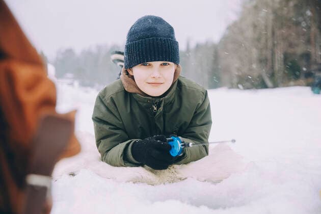 Creative Highlights Symbolbilder Portrait of smiling boy in knit lying on snow Sweden, Stockholm, model released Copyright: xMaskot,xMaskotxBildbyraxABx , MA94810 MA94810