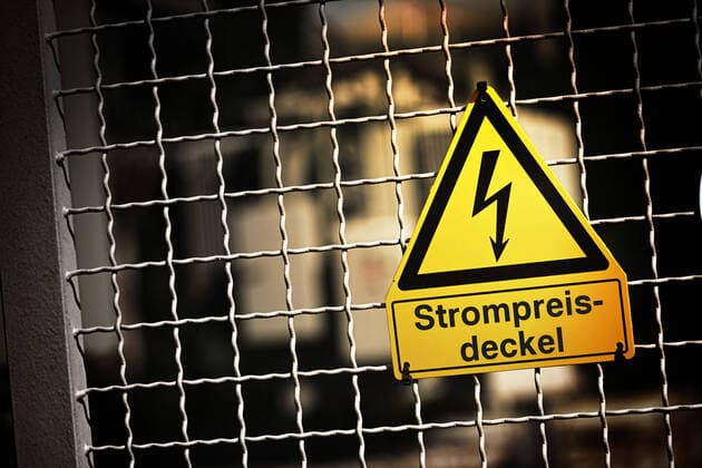 FOTOMONTAGE, Schild mit Strompfeil und der Aufschrift Strompreisdeckel *** PHOTOMONTAGE, sign with electricity arrow and the inscription electricity price cap. ** NUR FUER REDAKTIONELLE ZWECKE ** EDITORIAL USE ONLY **