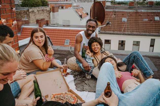 IMAGO Creative, Urban Lifestyle IMAGO Kreativ: Urbane Kultur - Sommer auf den Dächern Happy male and female friends with pizza enjoying party on rooftop Germany, Berlin, model released, property released Copyright: xMaskot,xMaskotxBildbyraxABx , MA95145 MA95145