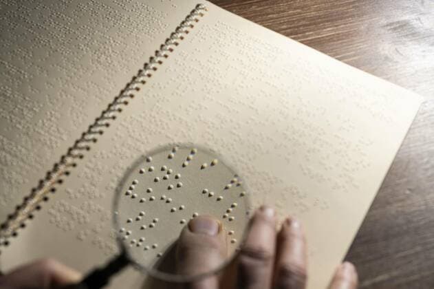  Braille alphabet book page, the focus of a magnifying glass on a page written in the Braille alphabet, the tactile reading system in relief for the blind, the focus of a magnifying glass on a page written in the Braille alphabet, the tactile reading system in relief for the blind, 29.11.2021, Copyright: xsergiodvx Panthermedia30930366.jpg