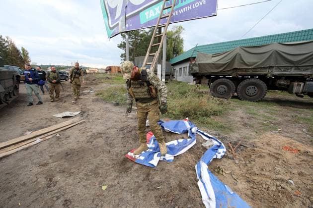 IZIUM, UKRAINE - SEPTEMBER 15, 2022 - A Ukrainian serviceman tramples on a banner with Russian propaganda in Izium which was liberated from Russian invaders, Kharkiv Region, northeastern Ukraine. Izium in Kharkiv Region after liberation from Russian occupiers  Copyright: xVyacheslavxMadiyevskyyx