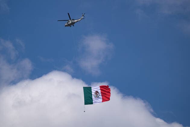 (220917) -- MEXICO CITY, Sept. 17, 2022 -- A helicopter carrying a national flag flies during the military parade for Mexico s Independence Day at the Zocalo Square in Mexico City, Mexico, on Sept. 16, 2022. Mexico on Friday celebrated the 212nd anniversary of its struggle for independence from Spanish colonial rule with a call for world peace and several commemorative activities. ) MEXICO-MEXICO CITY-INDEPENDENCE DAY-MILITARY PARADE XinxYuewei 