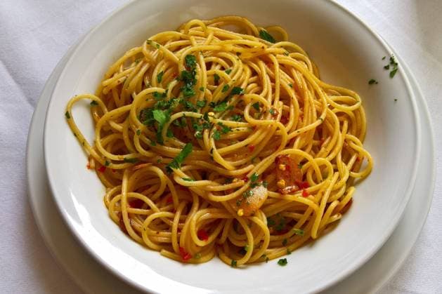Spaghetti Aglio Olio mit besonders viel Knoblauch. Pasta bzw Nudeln in einem italienischen Speiserestaurant *** Spaghetti Aglio Olio with extra garlic pasta or noodles in an Italian dining restaurant.