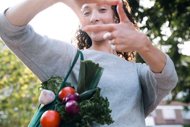 Woman with bag of vegetables looking through finger frame model released, Symbolfoto, AMWF00745