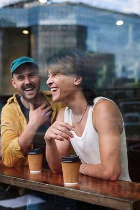 IMAGO Creative: Welttag für psychische Gesundheit am 10. Oktober Happy gay men with coffee cups seen through window of cafe model released, Symbolfoto, ASGF02846