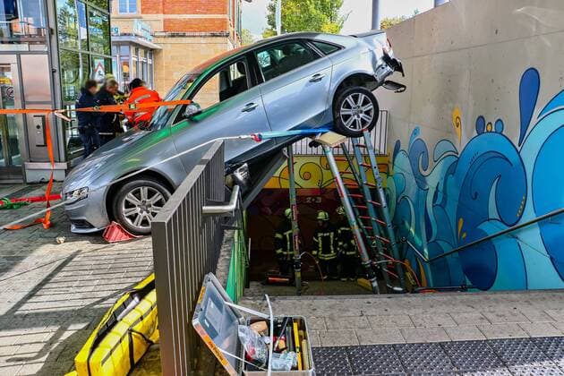 News Themen der Woche KW39 News Bilder des Tages Autofahrer (91) fährt rückwärts in Bahnhofsunterführung, Audi bleibt gerade noch auf Geländer hängen - Wagen schwebt rund drei Meter über nach unten führender Treppe 27.09.2022: Ein eher ungewöhnliches Bild zeigte sich am Dienstagvormittag Einsatzkräften der Polizei und Feuerwehr in Freiberg am Neckar. Aus bislang ungeklärter Ursache fuhr ein 91 Jahre alter Audi-Fahrer gegen 11:00 Uhr rückwärts über den Bahnhofsvorplatz in der Bahnhofstraße in Freiberg am Neckar. Der mit Automatikgetriebe ausgestattete PKW kollidierte mit dem Geländer des Treppenabgangs der Bahnhofsunterführung und kam auf diesem zum Stehen, sodass das Heck des Audi über die nach unten führende Treppe ragte. Der 91-Jährige blieb den bisherigen Erkenntnissen zufolge unverl