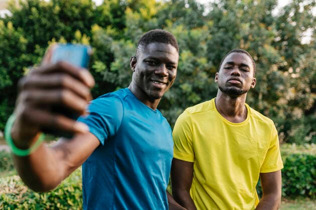 Smiling young man taking selfie with friend at park model released, Symbolfoto, EGAF02556