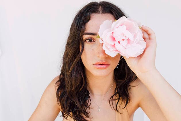 Creative Highlights Symbolbilder Young woman holding pink flower over eye model released, Symbolfoto, EGHF00523
