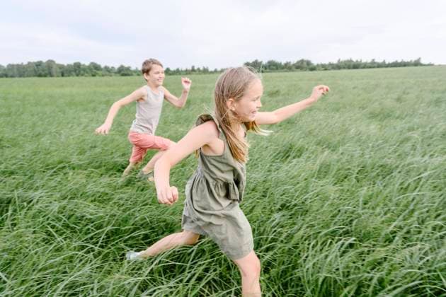 Happy siblings running on grass field model released, Symbolfoto, EYAF02147
