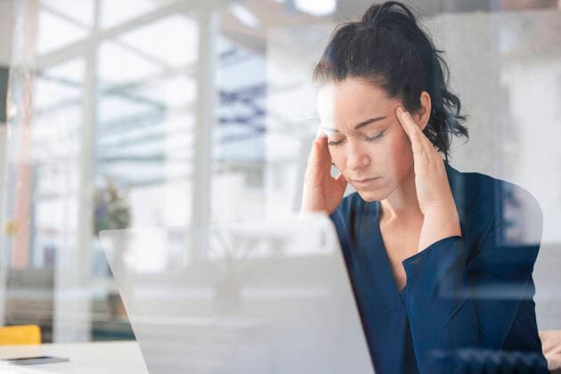 Businesswoman with eyes closed sitting in front of laptop seen through glass model released, Symbolfoto property released, JOSEF11991