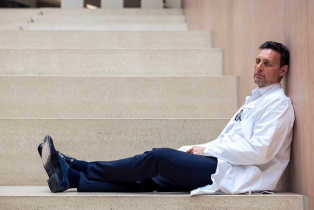 Mature doctor with napping on steps of hospital model released, Symbolfoto property released, JOSEF12727