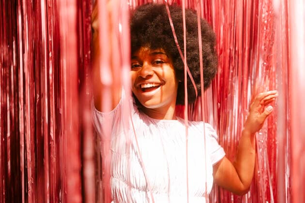 IMAGO Creative: Guten Rutsch Creative Highlights Symbolbilder Happy woman amidst tinsels having fun in party model released, Symbolfoto property released, MMPF00247