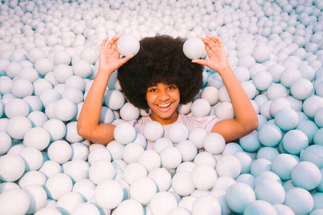 Creative Highlights Symbolbilder Happy young woman playing amidst ball pool model released, Symbolfoto property released, MMPF00260