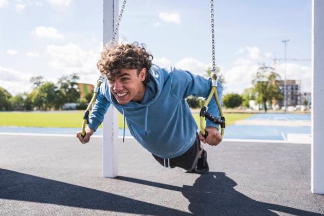 IMAGO Creative: 2022 Sport Favoriten IMAGO Creative: Welttag für psychische Gesundheit am 10. Oktober Happy sportsman exercising with suspension straps at sport court model released, Symbolfoto, UUF27156