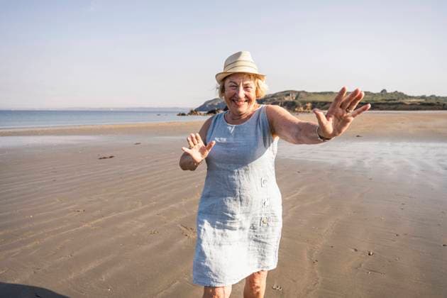 Creative Highlights Symbolbilder Cheerful senior woman dancing and having fun on beach at vacation model released, Symbolfoto, UUF27205