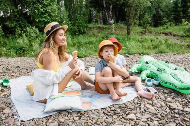 Woman eating ice cream with sons sitting on picnic blanket model released, Symbolfoto, VBUF00136