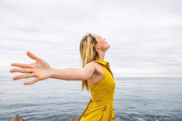 Creative Highlights Symbolbilder Carefree woman with arms outstretched by sea model released, Symbolfoto, WPEF06396