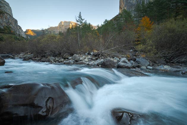 Fast stream of clean water flowing on rocks near mountain ridge covered with forest trees on autumn day in Ordesa y Monte Perdido National Park in Huesca, Spain, Model released JuanLopez_ID697_25461_030 Copyright: xJuanxLopezx MR